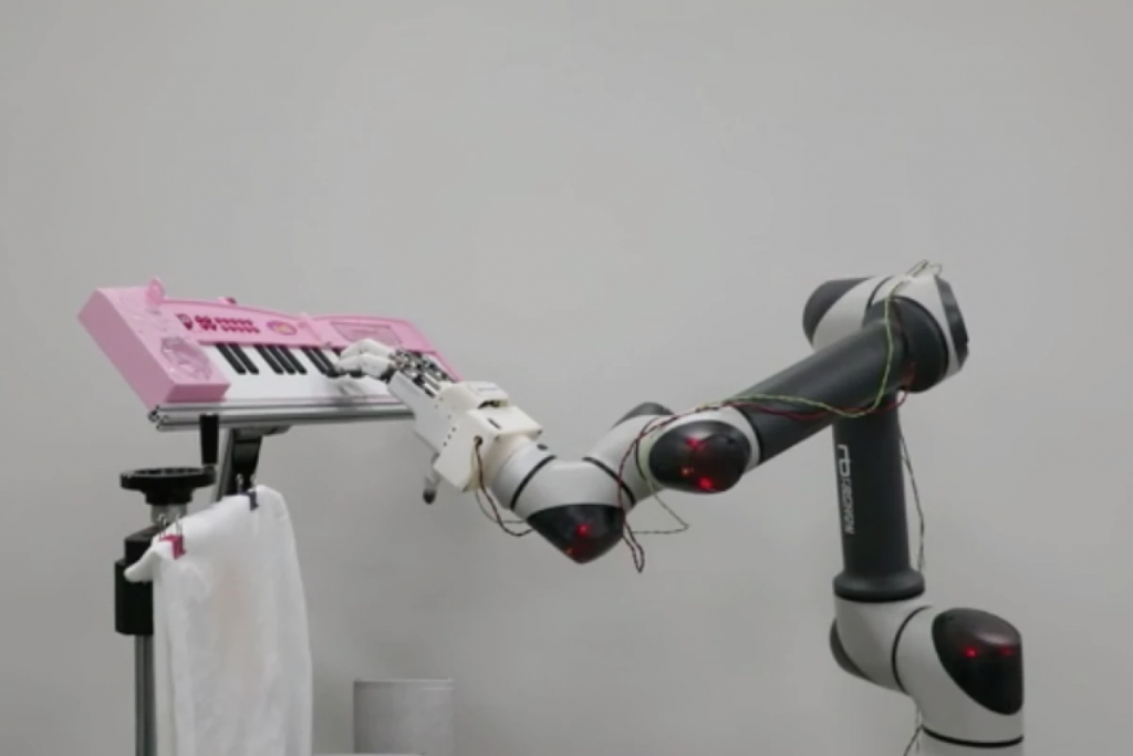 ROBOTIC HAND PLAYING THE PIANO, robot and robotic hand, piano and robot, music and robot,